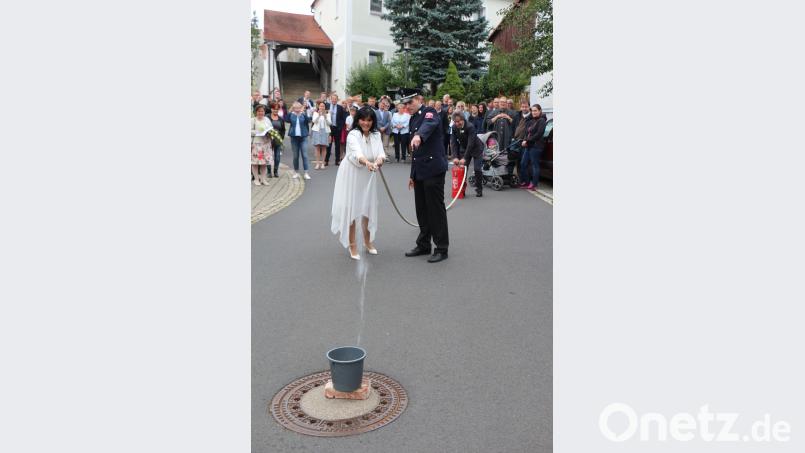 Das Brautpaar muss eine erste Bewährungsprobe bestehen. Der Bräutigam pumpt das Wasser in den Schlauch, und die Braut muss zielen. Doch der Eimer will einfach nicht fallen. rpp