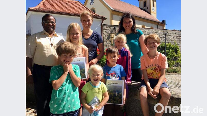 Pfarrer Moses Gudapati, Büchereileiterin Ute Beigel und HKV-Vertreterin Barbara Gerl (hinten links) freuen sich mit den Kindern über das neue Heimatjahrbuch 2017, das ab sofort in der Pfarrbücherei ausgeliehen werden kann. gri
