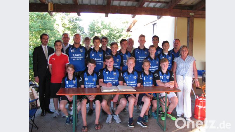 Die erfolgreiche C-Jugend der JFG Haidenaab-Vils mit Trainer Hans-Peter Schönl (hinten, Vierter von links) und Co-Trainer Thomas Bertelshofer (hinten, Zweiter von  rechts) trägt sich in das Goldene Buch des Marktes Mantel ein. sei
