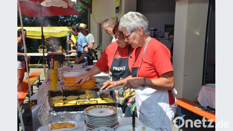 Elfriede Helgert und Lina Schuller-Wüst (von links) haben mit den Grillmeistern wohl den heißesten Arbeitsplatz an diesem Tag. dob