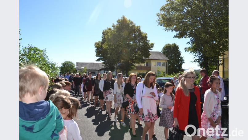 In schönen Firmkleidern machen sich die Kinder mit ihren Paten auf zur St. Georg Kirche. plym