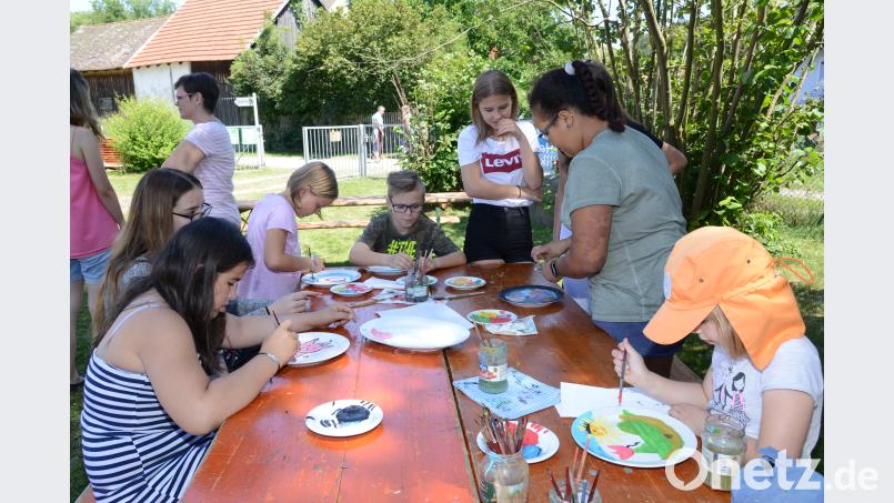 Die Kinder verzieren mit Begeisterung weiße Teller. bey