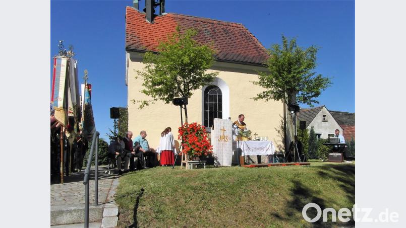 Zum Gottesdienst mit Pfarrer Heribert Stretz nehmen die Fahnenabordnungen der Vereine vor der Kapelle in Guttenberg Aufstellung. hl