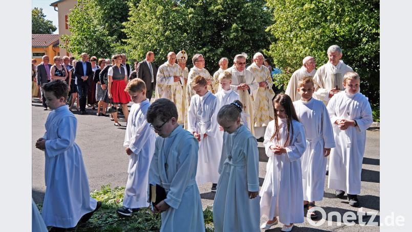 Die Ruhestandsgeistlichen, darunter der eremitierte  Bischof Dr. Bucher,  ziehen feierlich über den grünen Farnteppich ins Gotteshaus ein. twi