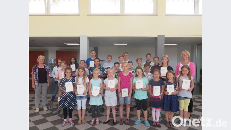Sportlehrerin Birgit Emerig (links) und Rektorin Christine Wiesend (rechts) gratulieren den Supersportlern der Grund- und Mittelschule Kemnath zu ihren herausragenden Leistungen und überreichen ihnen die Ehrenurkunden.. jzk