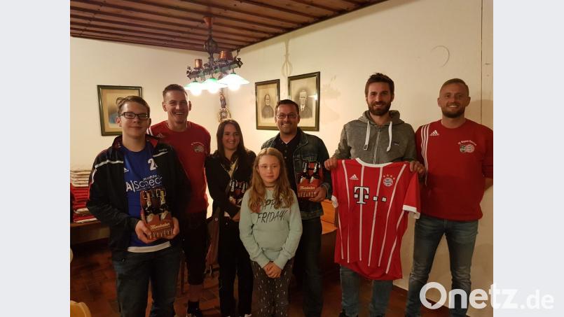 Die Gewinner der Verlosung beim FC-Bayern-Fanclub freuen sich über die Preise. Vorsitzender Thomas Grötsch (Zweiter von links), Stellvertreter Christian Kühn (rechts) und Glücksfee Ida Zenk (vorne) gratulieren. gi
