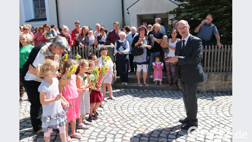 Beim Stehempfang vor der Kirche gratuliert auch der Kinderchor der Pfarrei dem Jubilar mit einem Lied. exb/Schwohnke