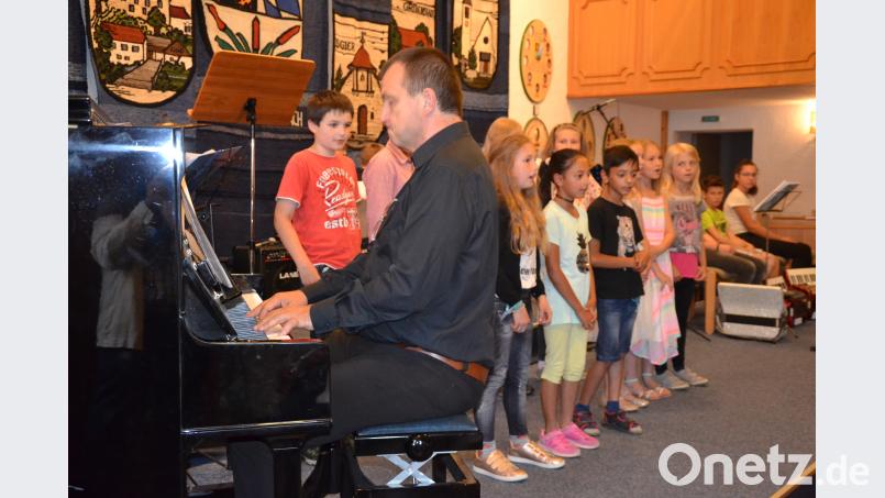 Musikschulleiter Wolfgang Ziegler begleitet den Chor der Grundschule zum Auftakt des Jahresabschlusskonzerts am Klavier. gi