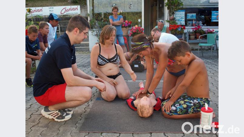 Christoph Bernhardt (links) von der Wasserwacht Vilstal-Kümmersbruck führte Badegäste in die Herz-Druckmassage und Mund-zu–Mund-Beatmung am Phantom ein. sön