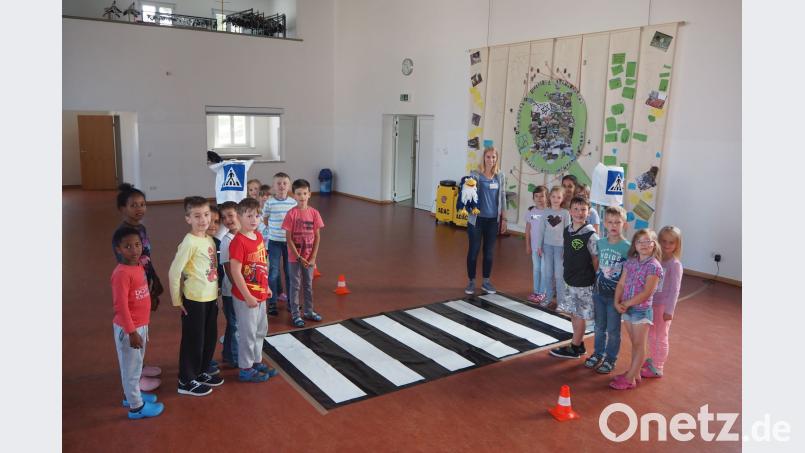 Die Erstklässler trainieren an einer Spielampel und einem Zebrastreifen mit ADAC-Mitarbeiterin Vera Seischab und dem kleinen Vogel &quot;ADACUS&quot; das Überqueren der Fahrbahn. gz