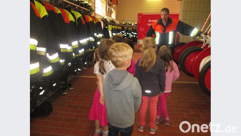 Interessiert lauschen die Kinder den Ausführungen des Feuerwehrmanns. exb