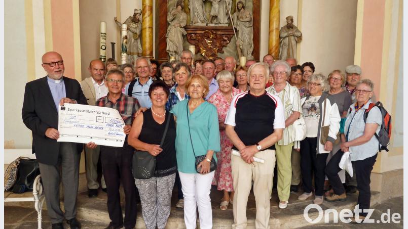 Die Besuchergruppe der „Freunde von Maria Kulm“ bei der Spendenübergabe vor dem Altar im Kreuzgang mit Pater Milan Kučera (vorne, links). rdo