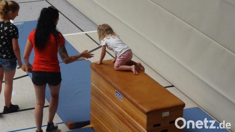Kleines Mädchen auf großem Kasten beim Sport-Parcours. Bild: hka