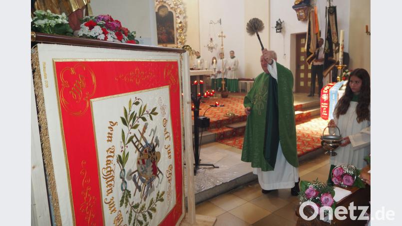 Pfarrer Erwin Bauer segnet die Vereinsfahne von 1924. Bild: gz GZ