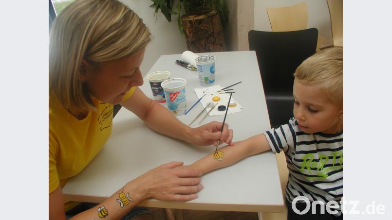 Jakob bekommt ein Bienchen auf den Arm gemalt. GIS