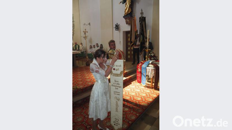 Festbraut Lisa Wagner und heftete ihr Erinnerungsband an die historische Vereinsfahne, die Florian Lindner tragen durfte. Bild: gz GZ