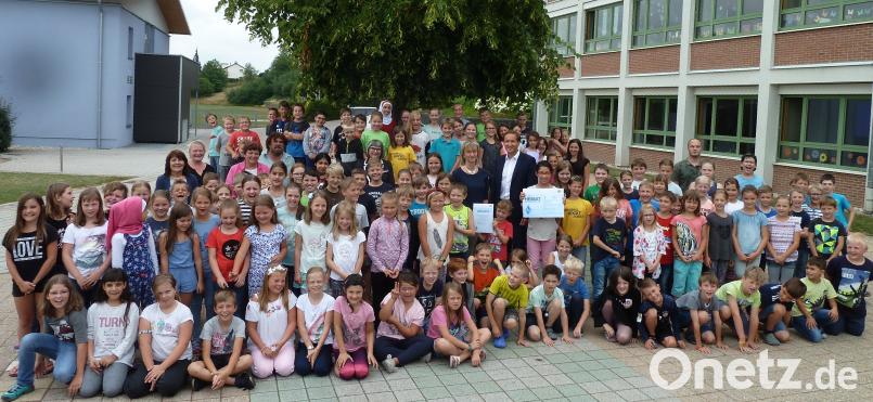Schulrat Jürgen Bomertl übergibt an Rektorin Beate Vetterl (Bildmitte) in Anwesenheit der Schulfamilie einen Scheck und eine Urkunde des Schulamtes Schwandorf. Portner