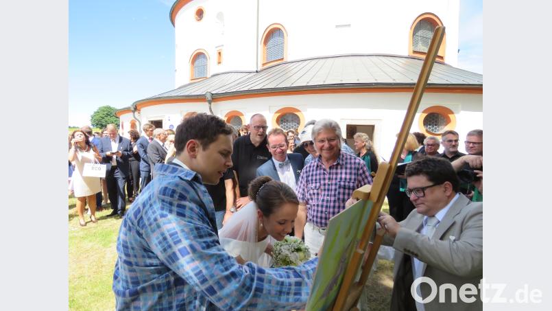Luca und Jenny Frank bekamen vom Verein Kunsthaus Waldsassen e. V. die Aufgabe, ein Bild zu malen. Ob sie das meistern, beobachteten aufmerksam Zweiter Vorsitzender Markus Braun (re.), Künstler Tom Brankovic (Mitte), Brautvater und KuWa-Vorsitzender Wolfgang Horn sowie die Festgäste im Hintergrund. UBB