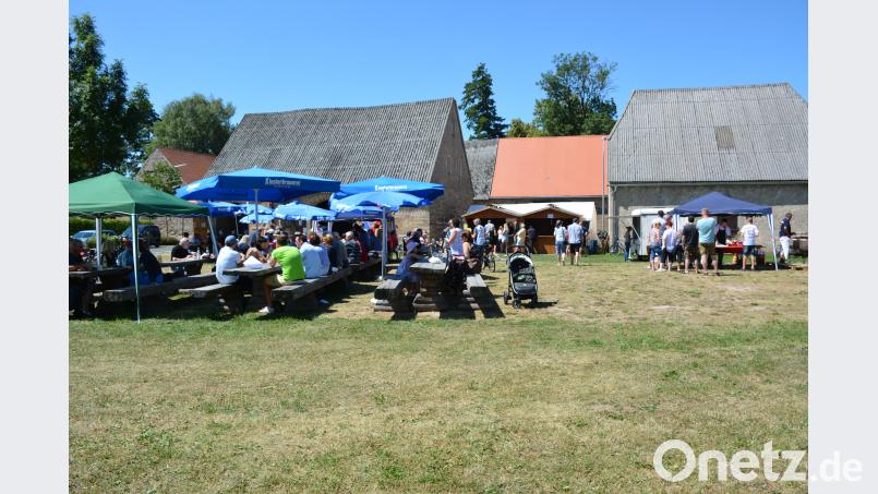 Die Besucher genießen die Spezialitäten unter den Sonnenschirmen. ak