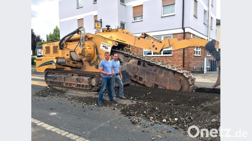 Durch den Einsatz dieser Felsgrabenfräse kann die komplette Granulatschicht in der Gailoher Hauptstraße ohne Erschütterungen und Lärmbelästigung auf 550 Metern innerhalb eines Tages ausgebaut werden. Stadtwerke-Meister Jürgen Brunner (links) und Betriebsingenieur Stefan Prüfling kümmern sich darum, dass die Arbeiten wie geplant erledigt werden. Stadtwerke Amberg/exb