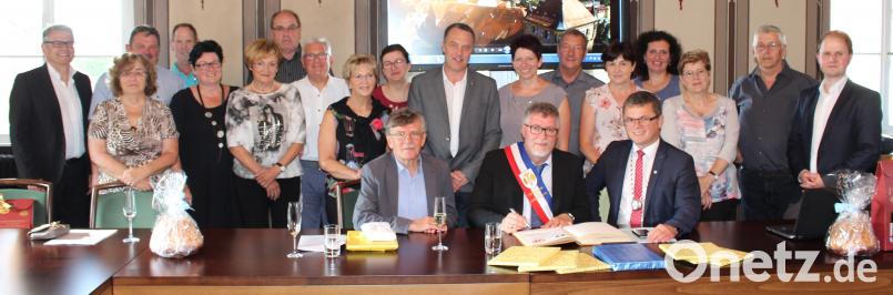 Bürgermeister André Lehmes (vorne Mitte) trägt sich beim Empfang der Delegation ins Goldene Buch ein, flankiert von Bürgermeister Martin Birner (vorne rechts) und Ehrenbürger Theo Männer (links). sns