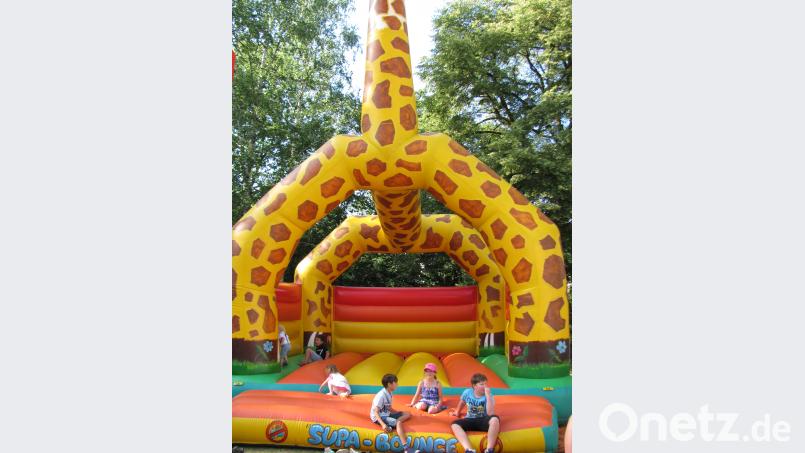 Die Kinder toben sich in der Hüpfburg in Form einer riesigen Giraffe aus. sei