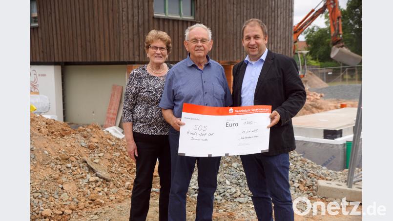 Das SOS-Kinderdorf Oberpfalz beherbergt neben acht Familien eine Vielzahl weiterer Einrichtungen für die Betreuung von Kindern. Zurzeit entsteht ein Anbau für die Aufnahme einer neunten Familie. Vor der Baustelle übergibt Hermann Heibl (Mitte) mit seiner Frau Reingard den Scheck von 1740 Euro an Dorfleiter Holger Hassel. bkr