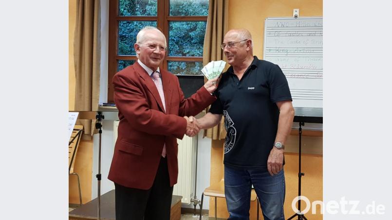 Vorsitzender Joseph Ferstl (rechts) freut sich zusammen mit den Musikerinnen und Musiker über die großzügige Spende von Josef Eimer (links). bph