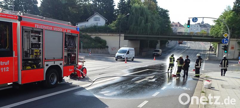 Mitglieder der Feuerwehr reinigen die Straße nach dem Unfall. rdo