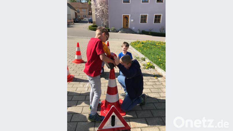 Die Kinder montieren eine Beleuchtung auf die Pylone. Es ist eine der Aufgaben der Feuerwehr beim Absichern einer Unfallstelle. Carina Völkl