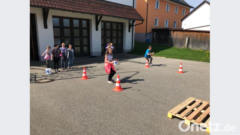 Die Kinder üben ihre Geschicklichkeit und versuchen, möglichst schnell möglichst viel Wasser über einen Parcours zu transportieren. Carina Völkl