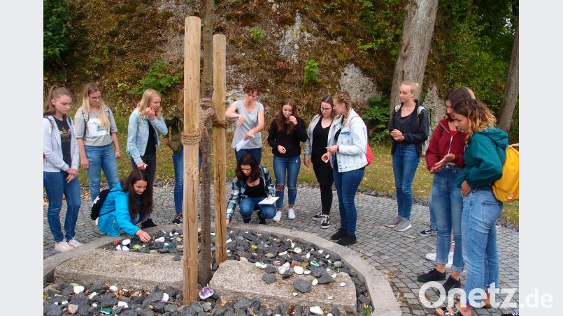 Die Schüler legten am „DenkMal“ – ein Baum mit zwei großen schweren Platten – symbolisch Steine ab, damit nicht vergessen wird, was nicht vergessen werden darf. exb