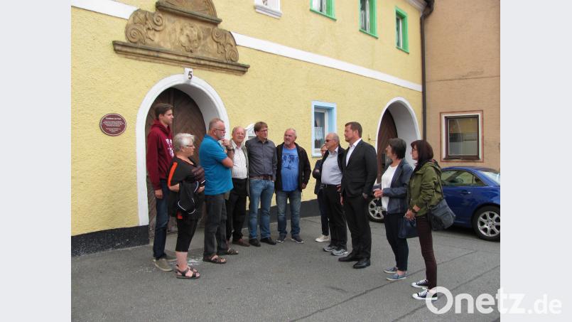 Bundestagsabgeordneter Uli Grötsch (Dritter von rechts) sieht sich in Mantel um. sei