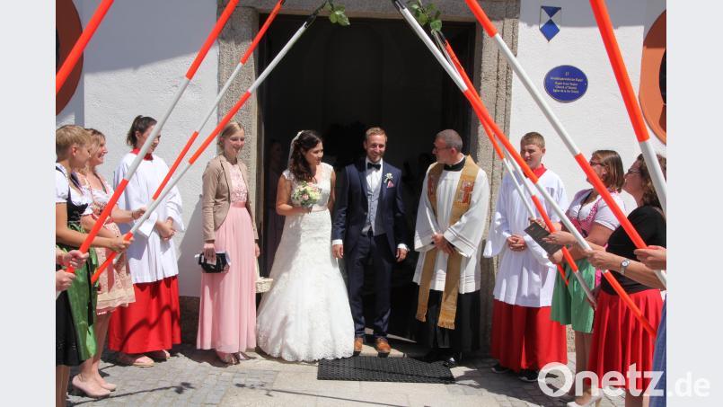 Nadine Härtl und Andreas Tretter, hier im Bild mit Pfarrer Thomas Vogl, gaben sich in der Kapplkirche das Jawort. Arbeitskollegen des Bräutigams bildeten ein Ehrenspalier mit Absteckpfählen. kro