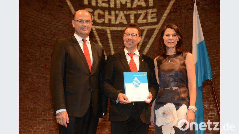 Finanz- und Heimatminister Albert Füracker (links) und Wissenschaftsministerin Marion Kiechle überreichen Markus Lommer die Urkunde. bey