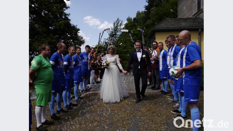 Vor der Kirche warteten der TSV Sportverein Arzberg-Rötenbach (vorne, im Fußball-Trikot) und die Fighting Ducks Schwandorf (hinten) im Spalier auf das junge Ehepaar. ebr