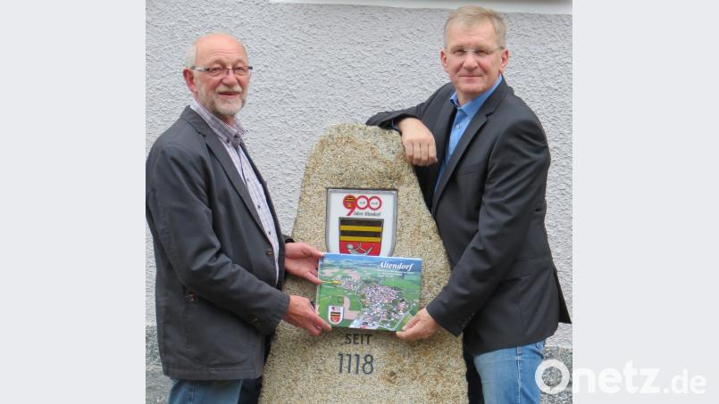 Der im April errichtete Gedenkstein am Gemeindezentrum erinnert an die erste urkundliche Erwähnung von Altendorf im Jahre 1118. Aus Anlass des Jubiläums hat Hans Baumer (rechts) ein Fotobuch mit über 400 historischen und auch neuen Bildern zur Ortsgeschichte erstellt. Das erste Exemplar übergab er an Bürgermeister Georg Köppl. Bild: Köppl