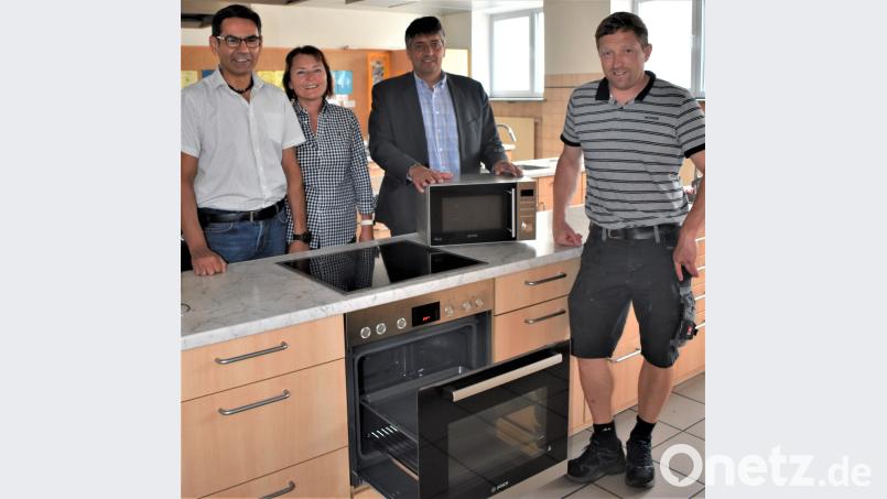 Rektor Thomas Schmidt (von links), Lehrerin Petra Arnold, Bürgermeister Edgar Knobloch und Schulhausmeister Tobias Schatz freuen sich, dass für die Schulküche mit der Förderung neue Elektrogeräte angeschafft werden konnten. rgr