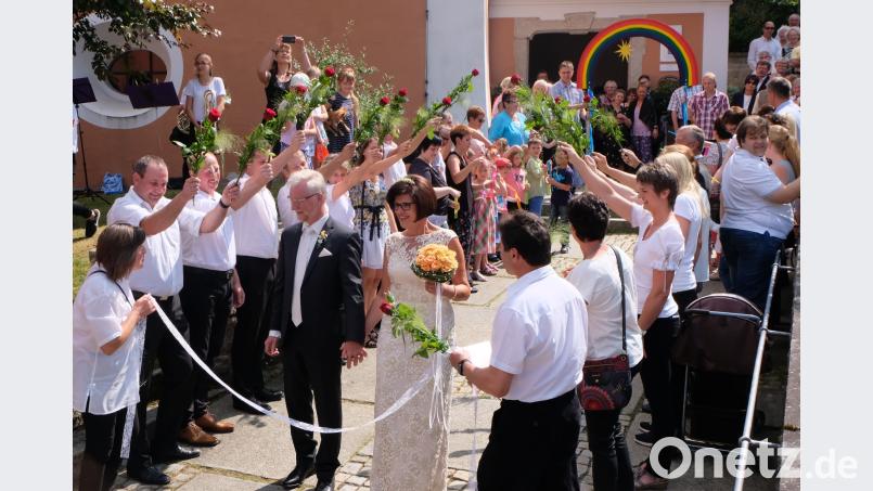 Die Haupertsreuther Dorfgemeinschaft steht mit roten Rosen Spalier. Pfarrer Wilfried Römischer und seine frisch angetraute Ehefrau Erika freuen sich über diese Überraschung. le