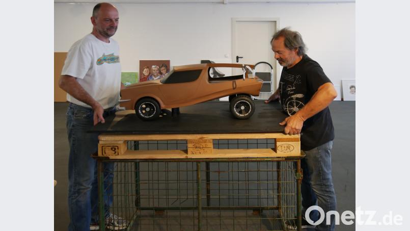 Die Fachlehrer Jürgen Heinl und Robert Seidl (von links) bauen die Präsentation auf. Das größte Modell ist eine Design Studie von Kai Gemeinhardt und heißt schlicht und einfach &quot;Pickup&quot;. tr