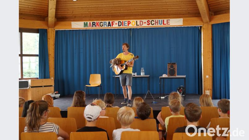 Die Lesung seines Kinderbuches ergänzt Oliver Scherz durch Lieder, während „Elefant“ Abuu auf seiner Gitarre wartet. jkt