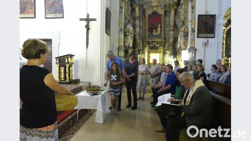 Beim Evensong stecken die Besucher symbolisch Sonnenblumensamen in einen Korb. fvo