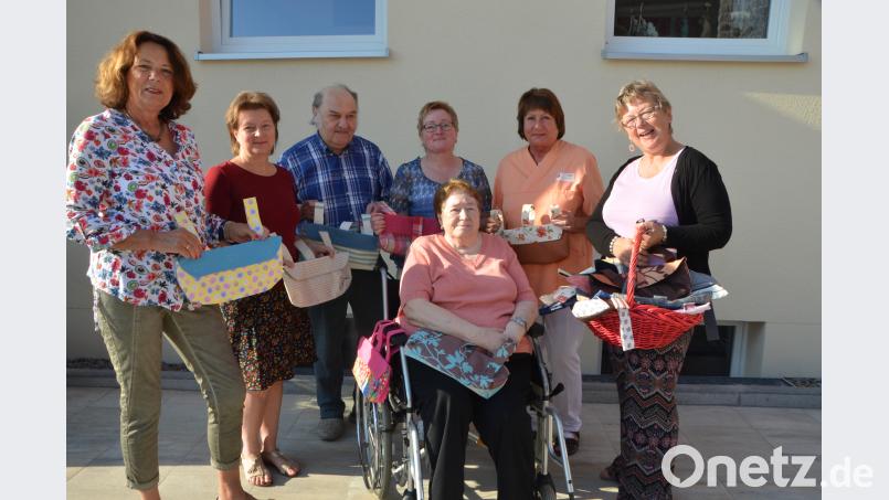 Mit einem Korb voller handgenähter Rollstuhltaschen überraschen Helga Wondrak aus Moosbach (links), Karin Wappmann (rechts) und Lydia Gajan (Dritte von rechts) die Rollstuhlfahrer im Walter-Siegert-Caritasheim. Bewohnerin Elisabeth Kindl sichert sich gleich eine. dob