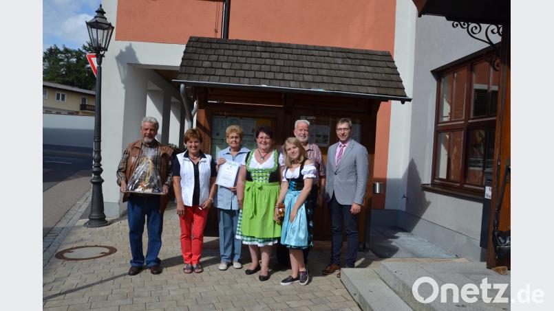 Bürgermeister Hermann Ach (rechts) ehrt treue Urlaubsgäste für den 45. und 35. Aufenthalt in der Marktgemeinde Moosbach. gi