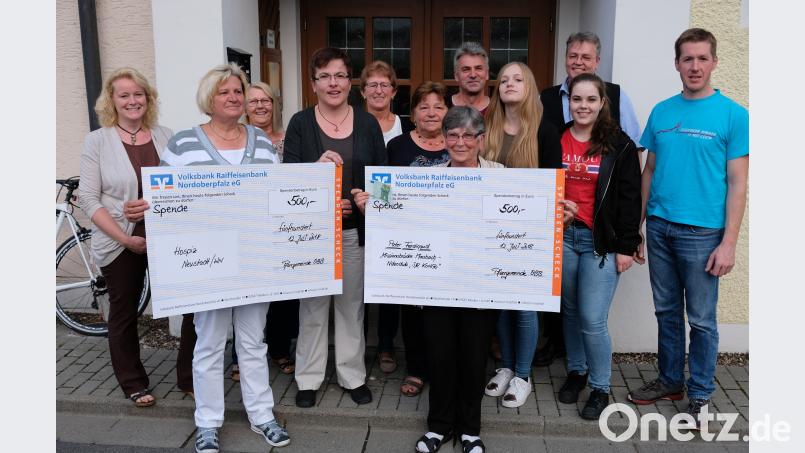 Spendenaktion im Oberbibracher Schützenheim St. Sebastian: Das Organisationsteam des Sternbittgangs um Irene Walter (Vierte von links) überreicht in Anwesenheit von Pfarrer Adrian Kugler (Zweiter von rechts) und Vertretern der Oberbibracher Vereine an Hildegard Haupt (Zweite von links), Mitglied des Hospiz-Koordinationsteams Weiden-Neustadt/WN, und Waltraud Burger (Sechste von rechts) für die Missionsstation von Augustinerpater Ferdinand Bodensteiner im Kongo jeweils 500 Euro. Marga Kreutzer (Sechste von links) stockt im Namen des Katholischen Frauenbundes die Spende an die Mission um 100 Euro auf. do