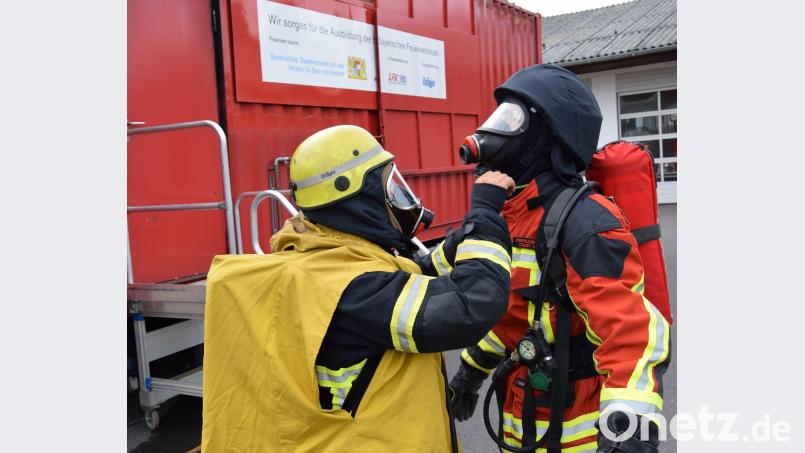 Der Trainer kontrolliert vor dem Durchgang im Container die Ausrüstung und Schutzkleidung auf richtigen Sitz. mde