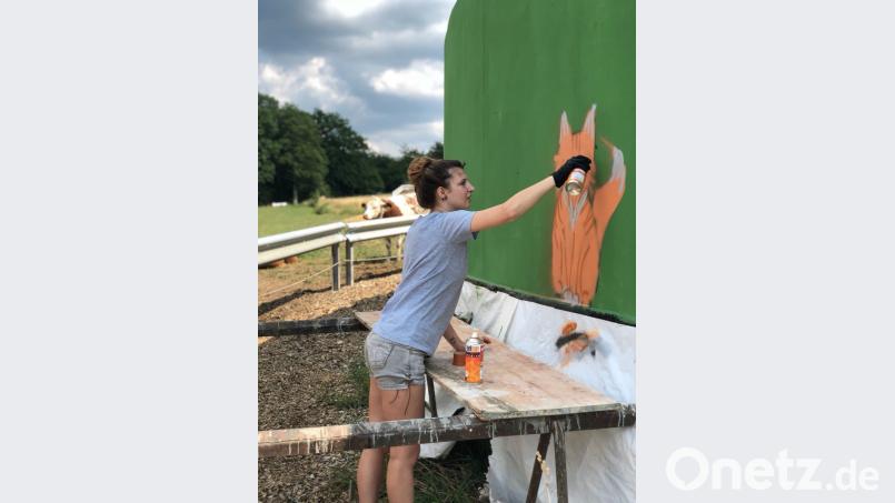 Die Schüler verwandeln die Betonwand in ein Kunstwerk. plym