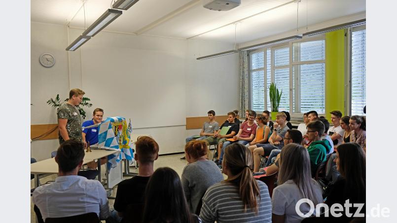 Beim Planspiel spricht ein Schüler als Abgeordneter im Plenum für seine Fraktion, dahinter der Landtagspräsident. twi