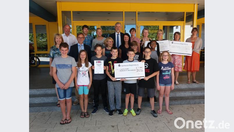 Die Vertreter aller Sieger-Schulen präsentieren stolz ihre Gewinne. Und die Ehrengäste gratulieren. e