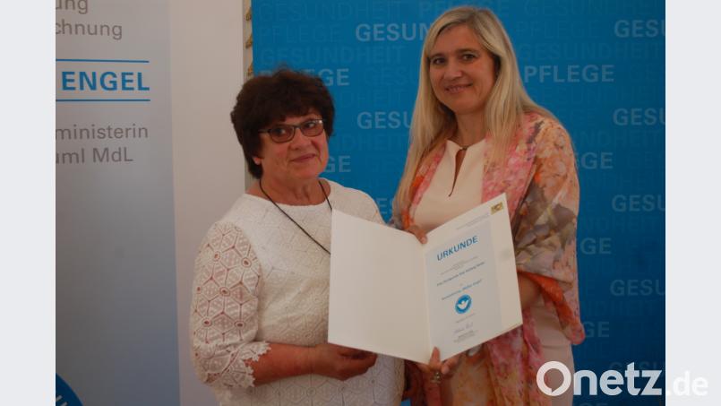 Gesundheitsministerin Melanie Huml dankt Rita Reiter mit der Urkunde „Weißer Engel“ für das ehrenamtliche Engagement. gib